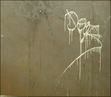 Graffiti sur un support en acier Corten. Fantôme d'un acien graffiti visible au coin supérieur gauche.