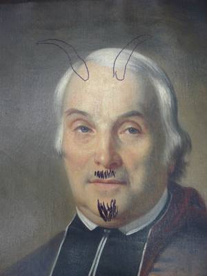 Portrait ayant été victime d'un graffiti ; des cornes et une moustache y ont été dessinés.